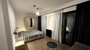 Ein modernes Schlafzimmer mit einem Bett, einem kleinen runden Tisch und einer Couch.