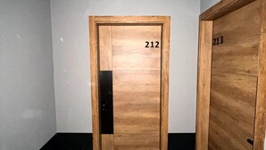 Ein Flur mit zwei Holztüren, auf denen 212 und 213 steht, der zu Zimmern führt.