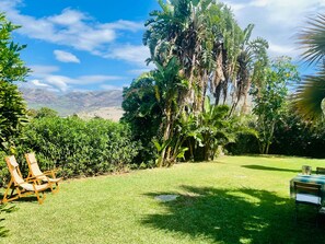A lush garden with a grassy lawn, a wooden swing set, and a table with chairs. - Las Palomas Coastal Retreat, Tarifa sleeps 2-4 (Tarifa)