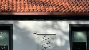 Een gebouw met een bord waarop 'Casa de Casiano' staat en een brandmeldbox eronder.