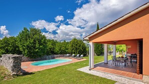 A backyard with a swimming pool, a barbecue area, and a stone wall. - Pool House in Greenery near Trget, Labin, Croatia (Labin)