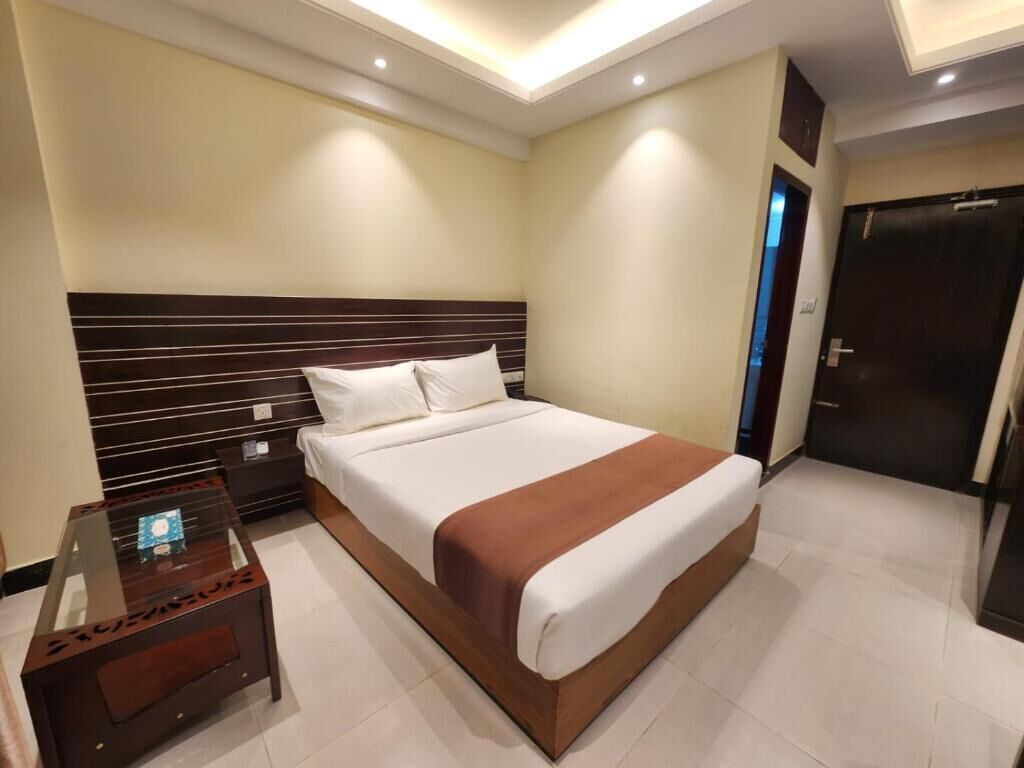 Una habitación de hotel con una cama grande, una mesita de noche y un armario.