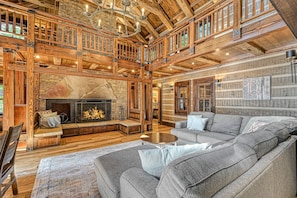 Cozy retreat with a high ceiling, fireplace, and comfortable seating area.