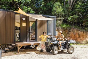 A wooden cabin with a sliding door, a picnic table, and a canopy.