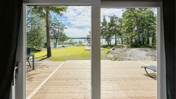 Une terrasse en bois offrant une vue sur un lac et des arbres.