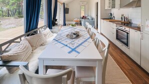 Une cuisine moderne avec des armoires blanches, un plan de travail en bois et un four encastré.