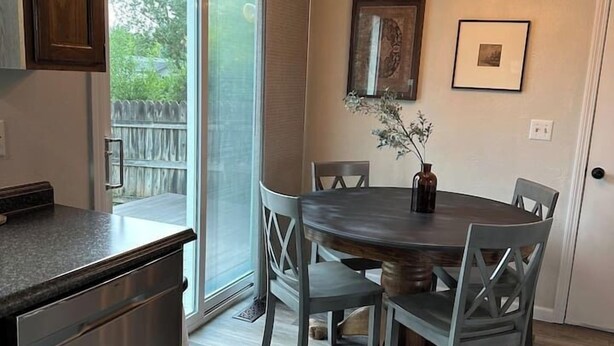 Una cucina moderna con zona pranzo, caratterizzata da una grande isola, elettrodomestici in acciaio inossidabile e un lampadario.