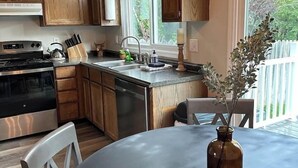 Una cucina moderna con mobili in legno, elettrodomestici in acciaio inossidabile e un'ampia finestra che offre vista sull'esterno.