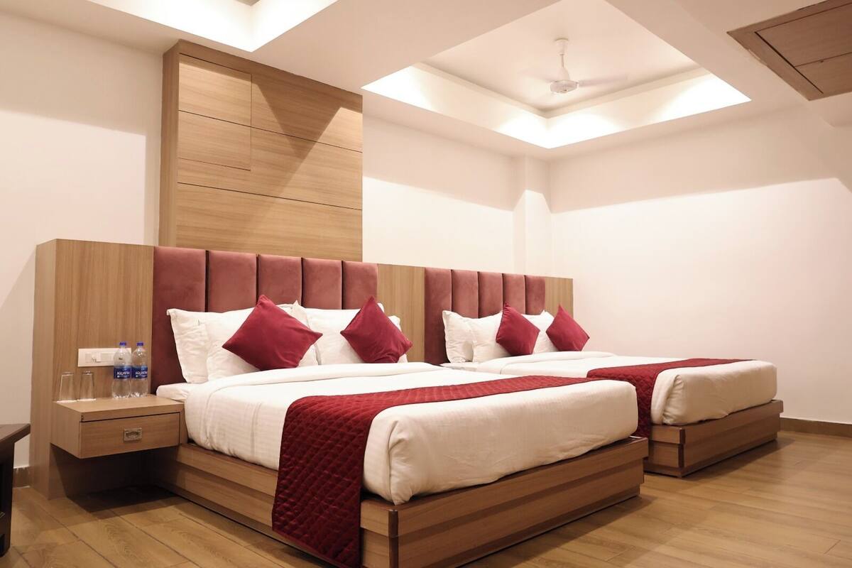 A modern hotel room with a large bed, wooden headboard, and a skylight.