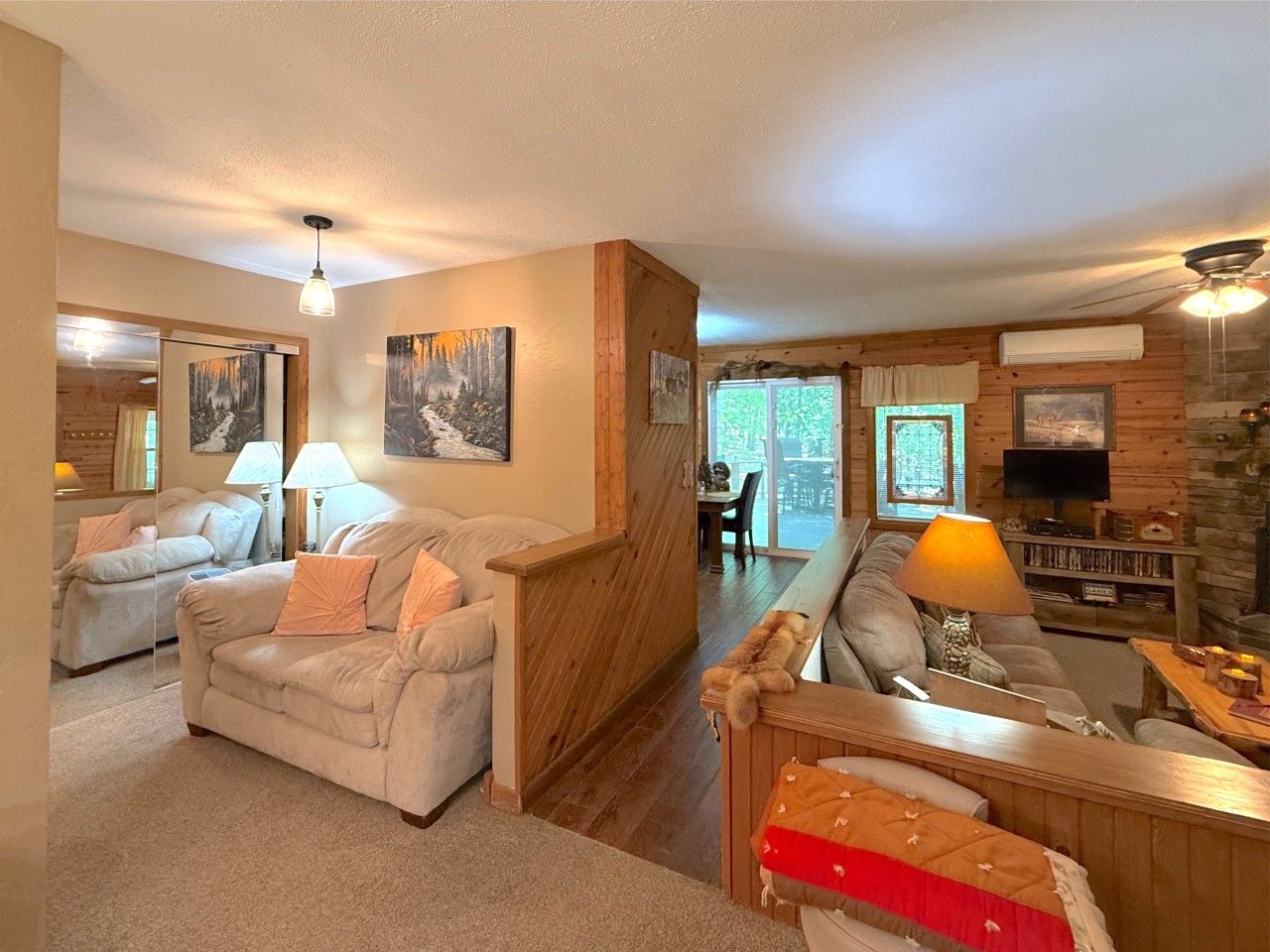 A spacious living room with a fireplace, a dining area, and a view of the outdoors.