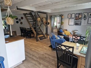 A cozy living area with a staircase, a dining table, and a sofa.