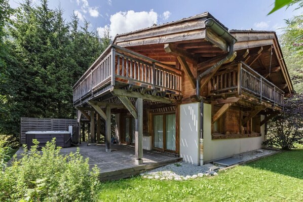 Une cabane en bois dotée d’un balcon, d’un jacuzzi et d’une terrasse.