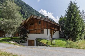 Un chalet en bois doté d’un toit à pente, de fondations en pierre et d’un escalier menant à l’entrée.