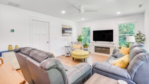 A modern living room with leather sofas, a wooden coffee table, and a fireplace. - Newly Built Home Near Morrison Rockwood State Park (Morrison)