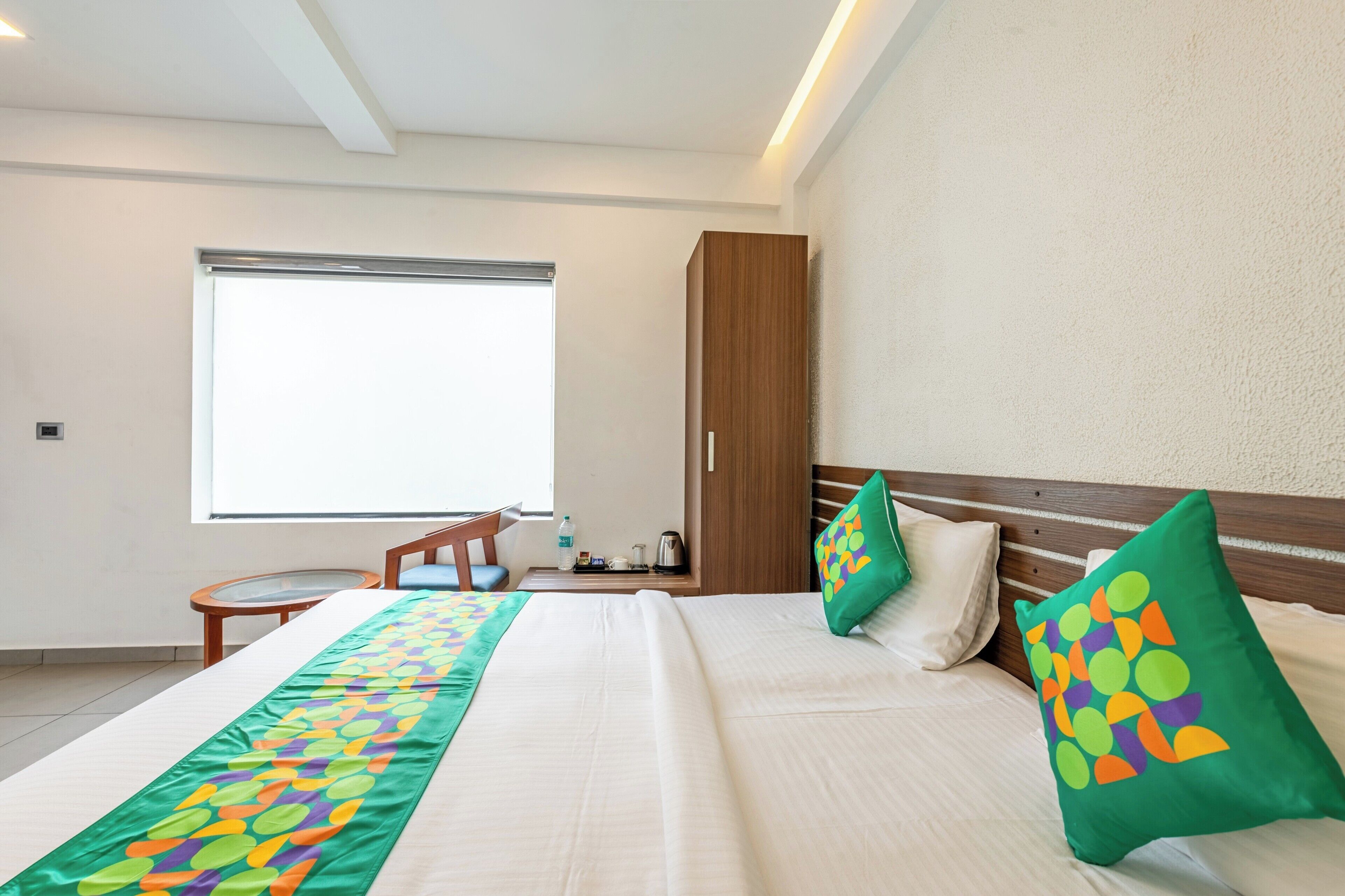 Une chambre d’hôtel avec un grand lit, deux oreillers, un bureau et une fenêtre.
