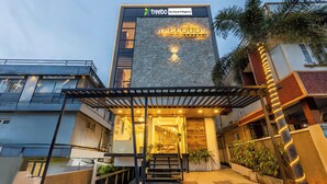 The exterior of De Cloud 9 Regency hotel with a stone facade, a covered entrance, and a staircase leading to the entrance. - Treebo De Cloud 9 Regency (Thiruvananthapuram)