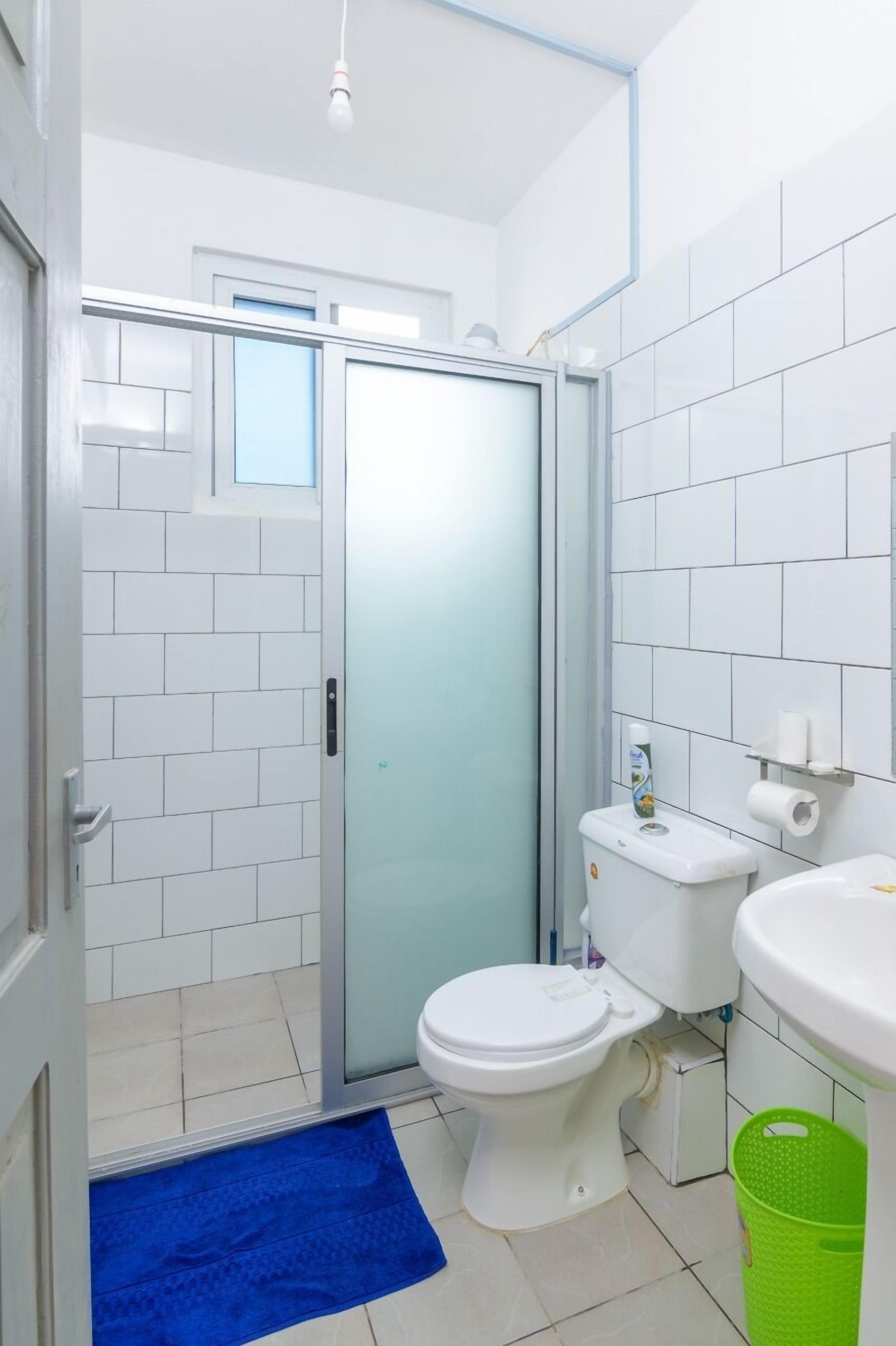 Un baño con inodoro, lavabo y zona de ducha.
