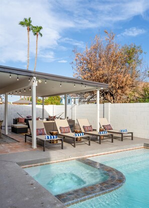 A poolside area with lounge chairs and a covered seating area. - Rock Climbing Wall~Pool& Mini Golf~Game Room~Mural (Peoria)