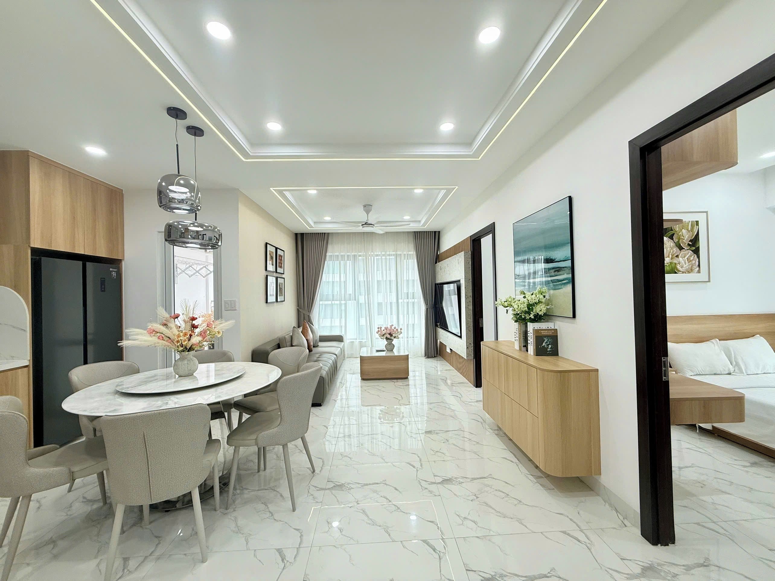 Una habitación de hotel moderna con comedor, cama y televisor.