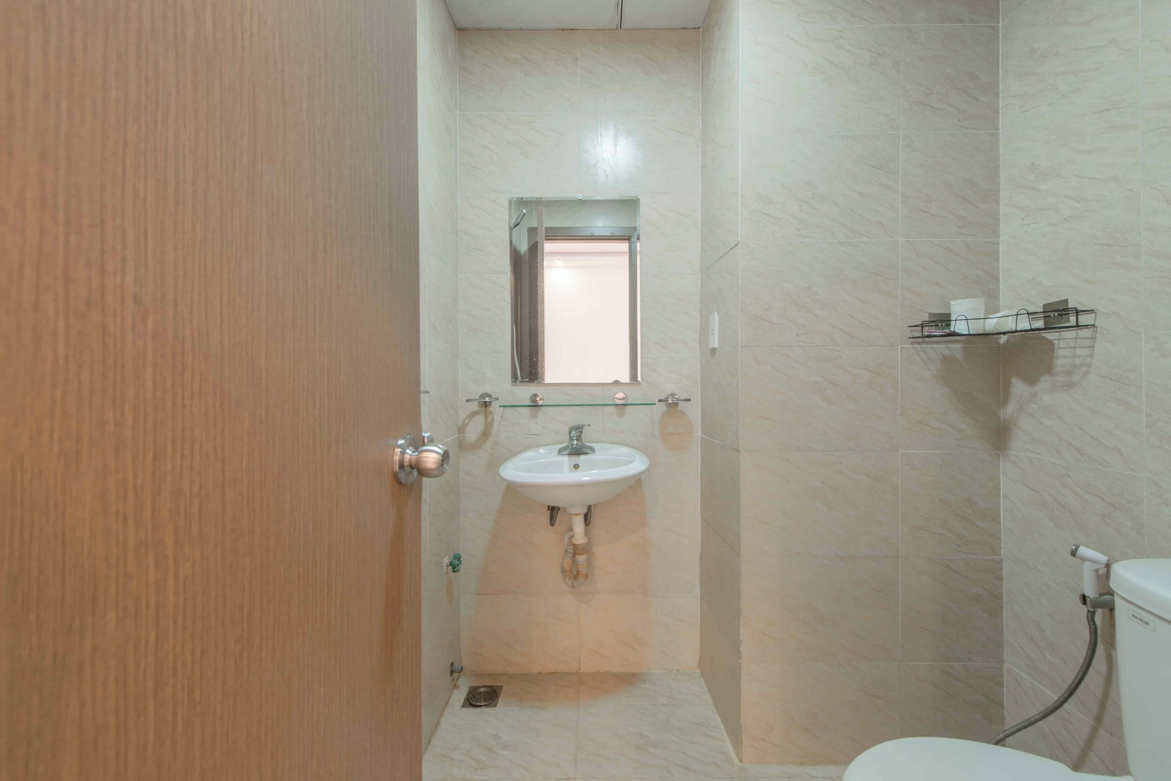 Un baño con lavabo, espejo e inodoro.