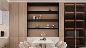 A modern dining area with a marble table and six chairs, a built-in bookshelf, and a sleek sofa. -  Oceanus Vien Trieu Nha Trang Apartment - Thai Ha (Bac Nha Trang)
