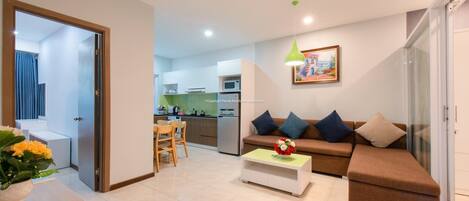 A modern living room with a sofa, a coffee table, and a dining area.