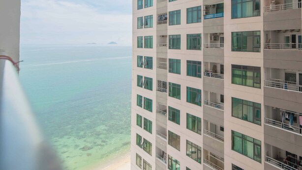 A high-rise hotel with multiple balconies overlooking a beach and ocean. -  Oceanus Vien Trieu Nha Trang Apartment - Thai Ha (Bac Nha Trang)