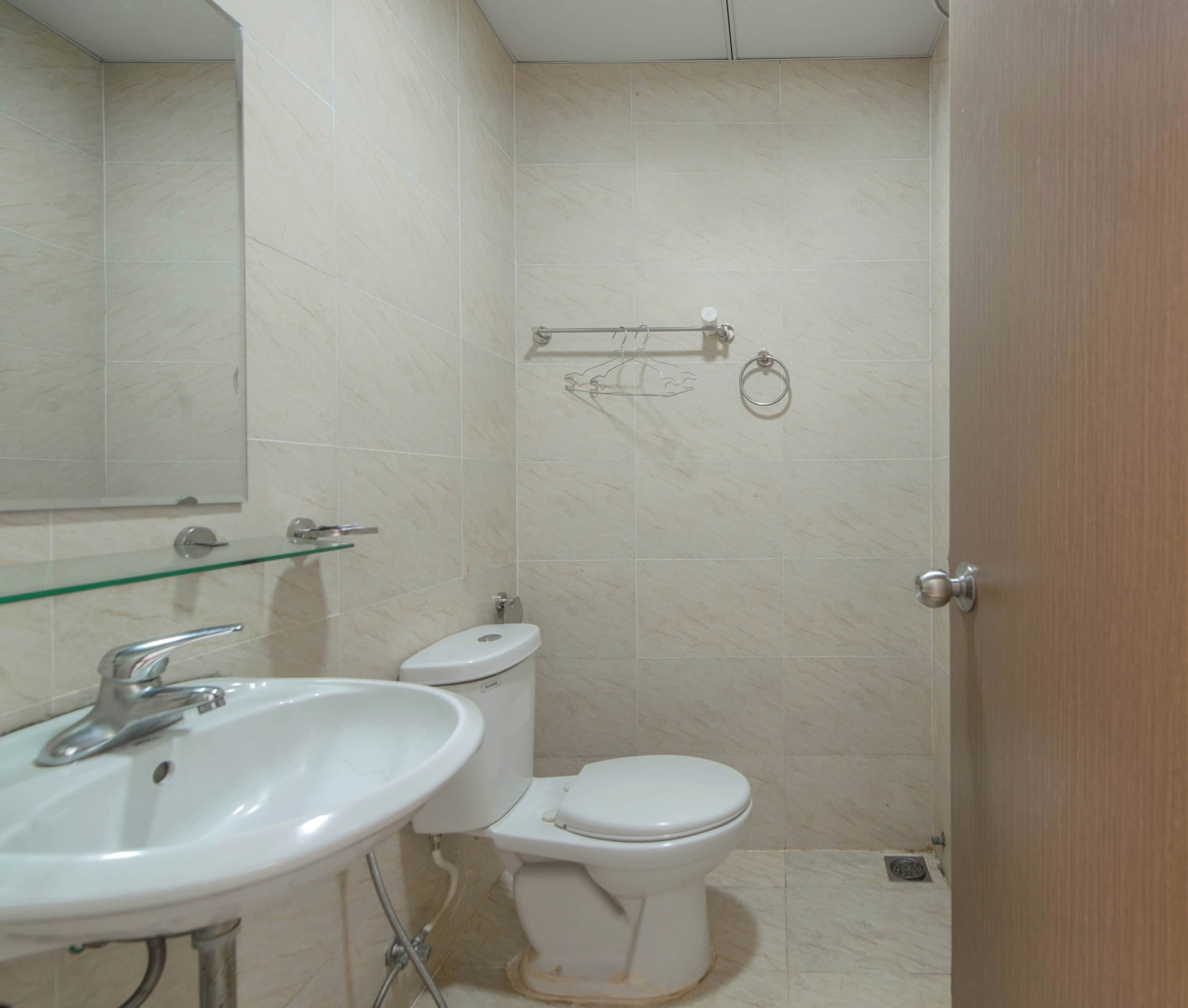 A bathroom with a white sink, toilet, and a glass shower enclosure.