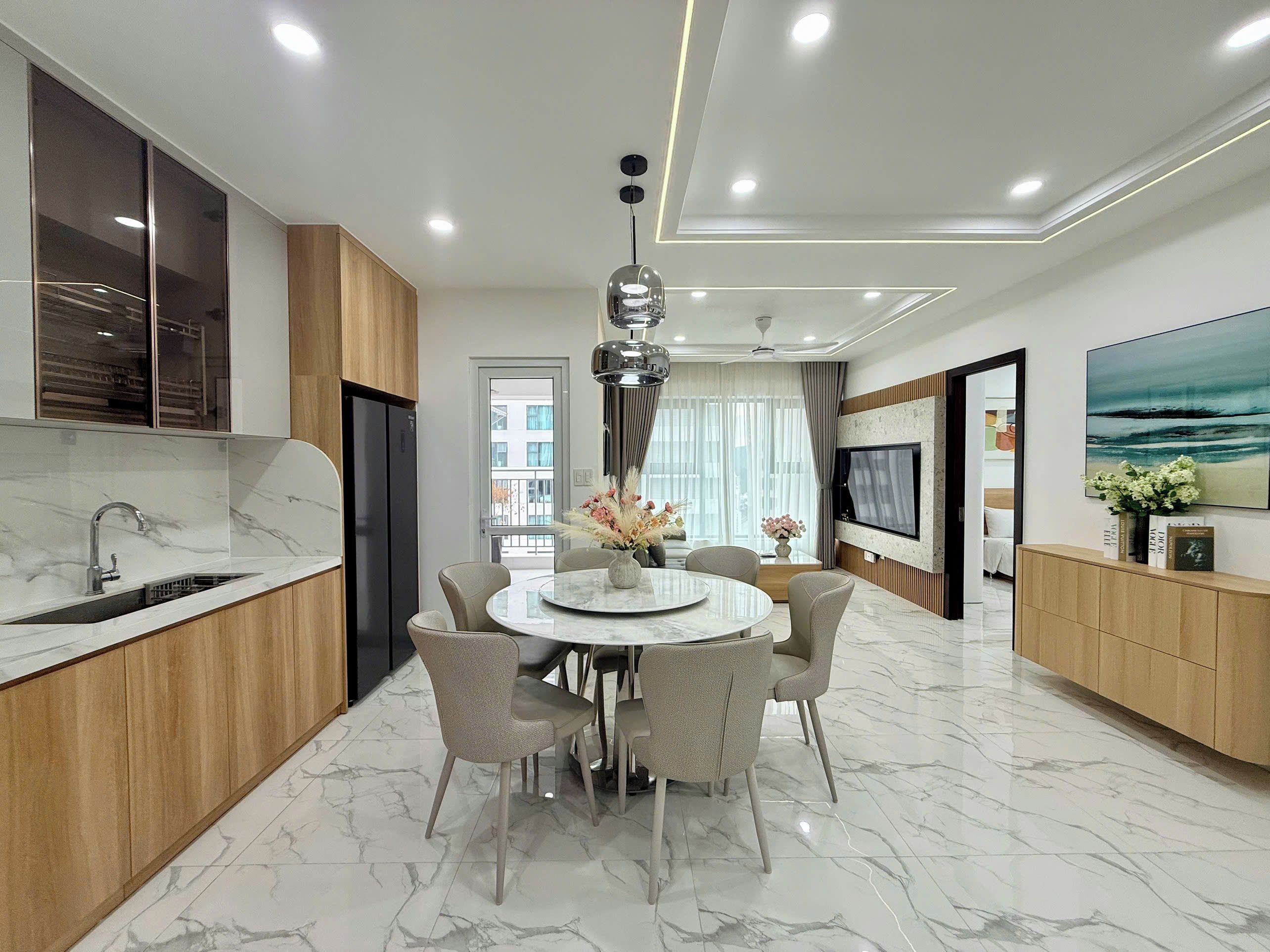 A modern kitchen with a marble countertop, wooden cabinets, and a built-in oven.