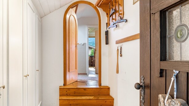 A wooden staircase leading to a room with a door, a window, and a wall-mounted coat rack. - Apartment 'Ferienwohnung Haus Greif' with Mountain View, Balcony and Wi-Fi (Garmisch-Partenkirchen)
