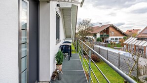 A balcony with a metal railing, a potted plant, and a chair. - Apartment 'Ferienwohnung Hobmaier' with Mountain View, Shared Garden and Wi-Fi (Forstern)