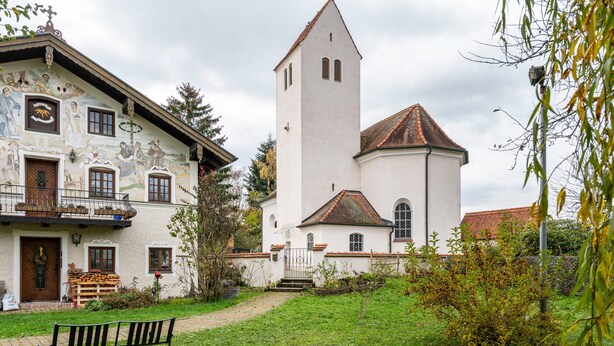 A traditional building with a tower, a bench in the foreground, and a pathway leading to the entrance. - Apartment 'Ferienwohnung Hobmaier' with Mountain View, Shared Garden and Wi-Fi (Forstern)