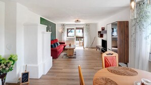 A living room with a red sofa, wooden coffee table, and a TV.