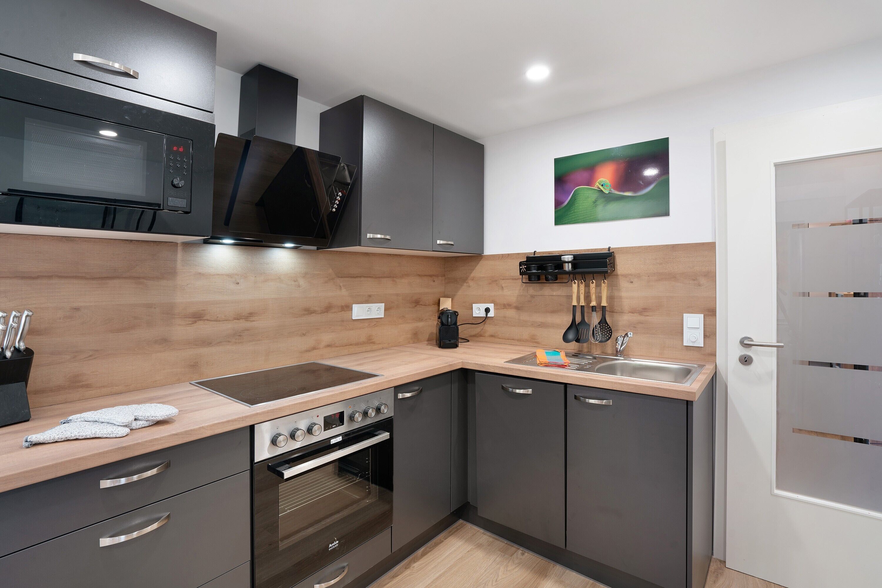 A modern kitchen with a microwave, stove, oven, and sink.