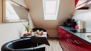 A small kitchenette with a red cabinet, a coffee maker, and a window. - Apartment 'Hexe I - Mit Blick Auf Den Wurmberg' with Mountain View, Balcony and Wi-Fi (Braunlage)