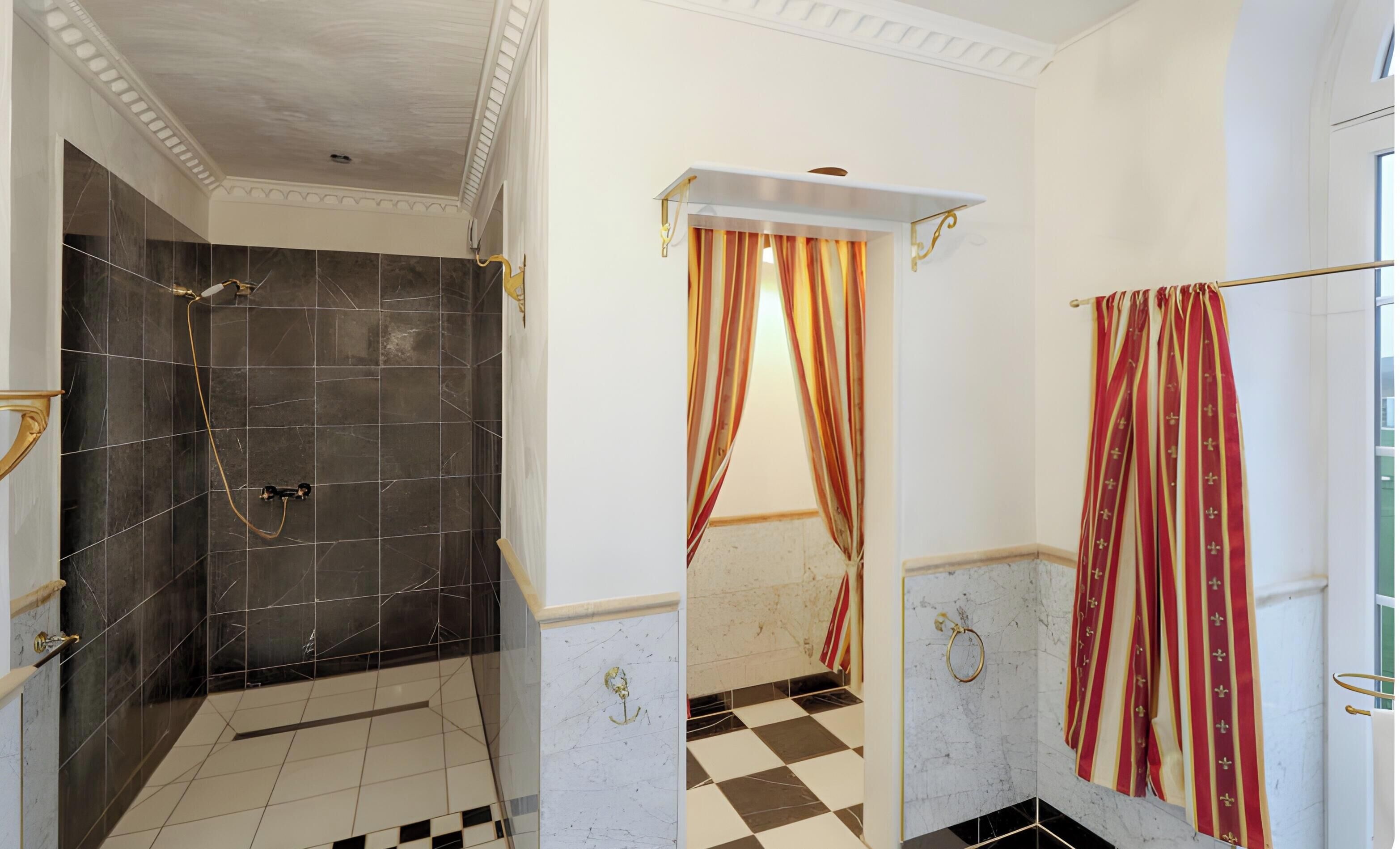 Baño con ducha, suelo de cuadros y un perchero.