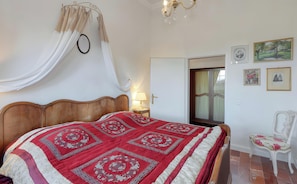 A bedroom with a wooden bed, a canopy, a nightstand, a chair, and artwork on the walls. - Apartment 'Panorama Suite' with Shared Garden and Wi-Fi (Emmelsbüll-Horsbüll)