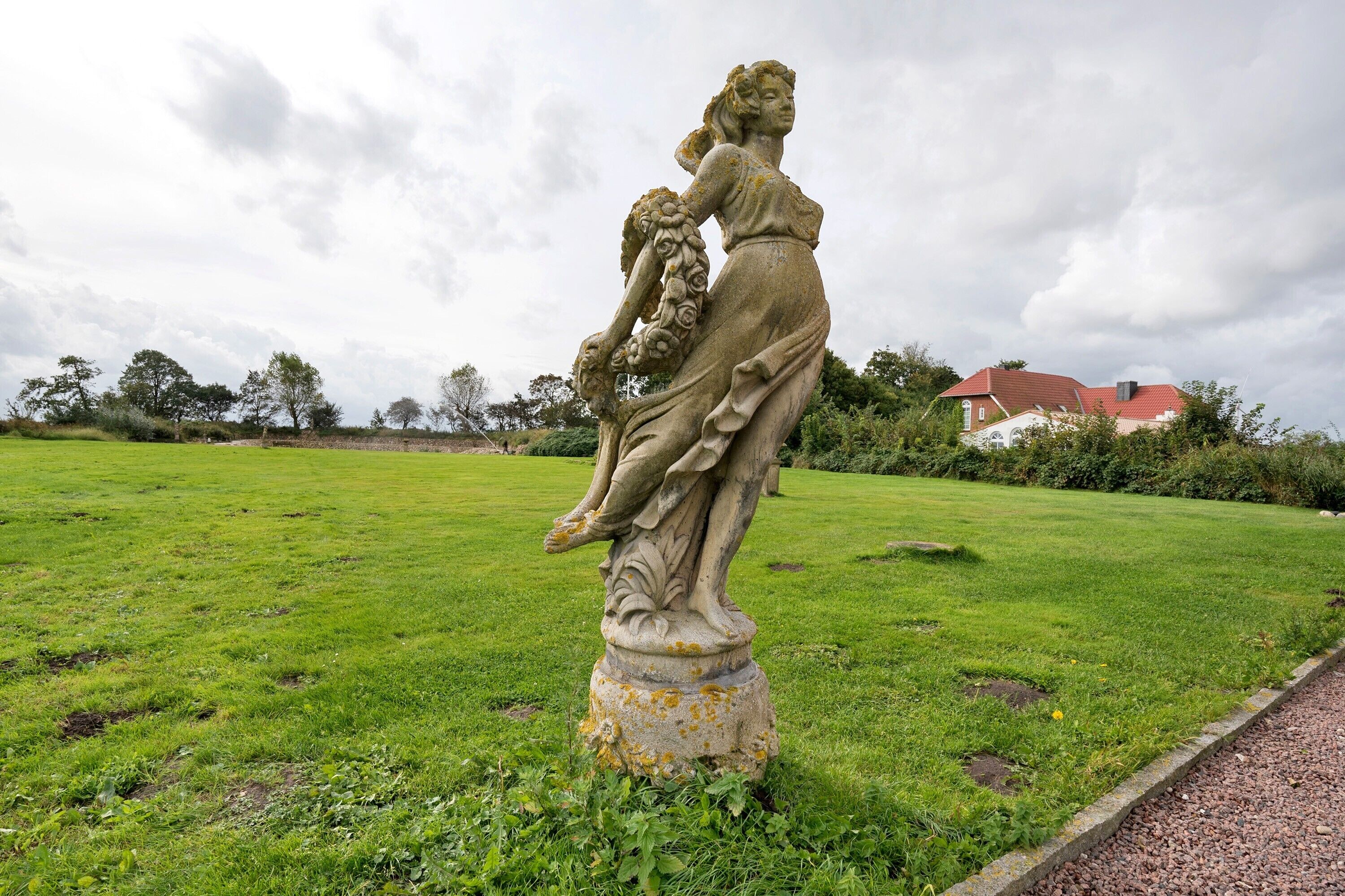 Una statua in un'area erbosa, con un edificio sullo sfondo.