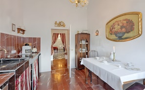 A hotel room with a kitchen, a dining area, a chandelier, a checkered floor, and a painting. - Apartment 'Panorama Suite' with Shared Garden and Wi-Fi (Emmelsbüll-Horsbüll)