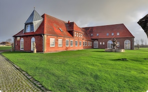 A large brick building with a prominent tower, a fountain, and a well-maintained lawn. - Apartment 'Panorama Suite' with Shared Garden and Wi-Fi (Emmelsbüll-Horsbüll)