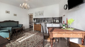 Una sala de estar con sofá, una mesa de madera y una araña.