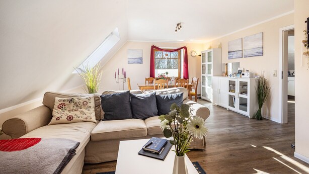 A spacious living area with a sofa, coffee table, and a dining area with a table and chairs. - Apartment 'Ferienwohnung Lemburg' with Shared Terrace, Shared Garden and Wi-Fi (Nindorf)