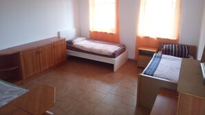 Un dormitorio con cama, escritorio, silla y armario.