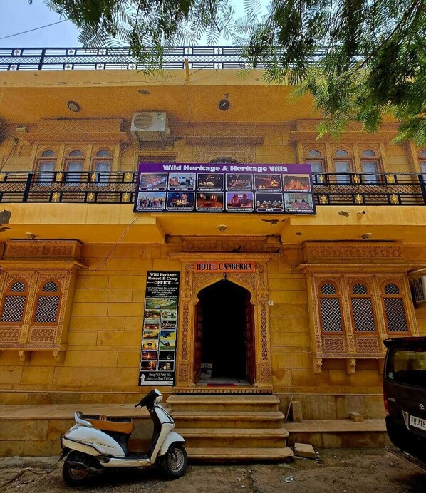 A hotel entrance with a sign for 'Hotel Canberra' and a poster for 'Wild Heritage & Heritage Villa'.