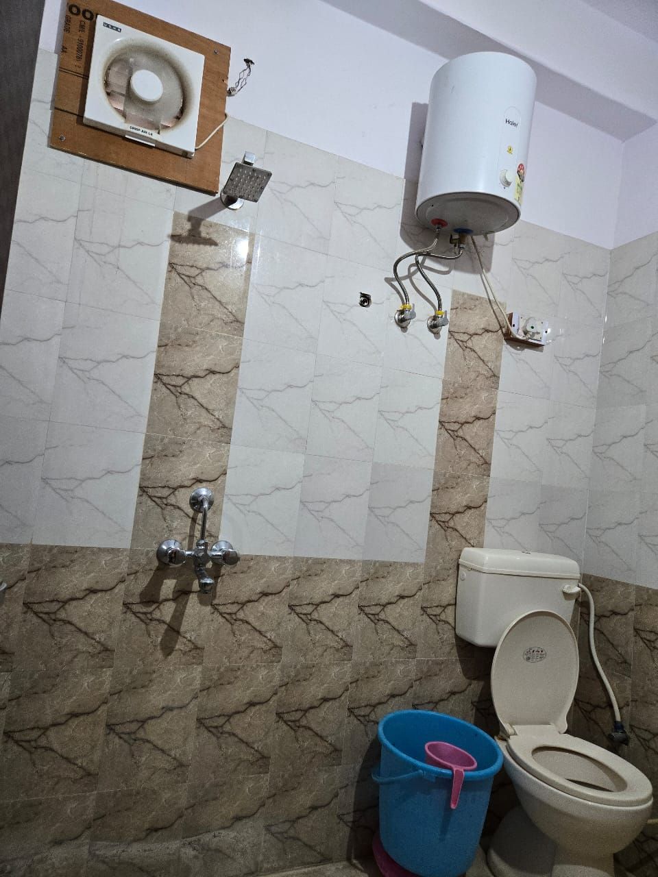 Un baño con inodoro, ducha y secador de manos.