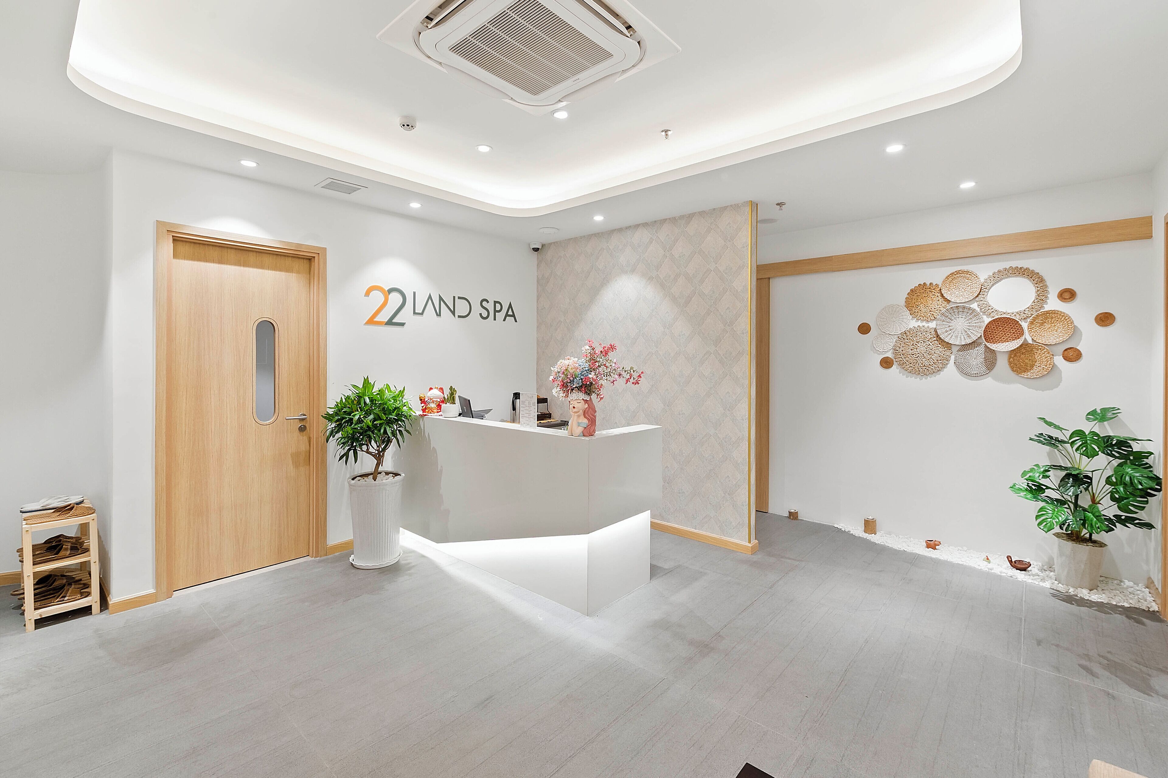 A reception area with a wooden door, a reception desk, and a wall with a geometric pattern.