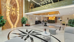 A modern hotel lobby with a large, intricate wall design, a reception desk, and a spacious seating area. - 22Land Hotel Saigon (Ho Chi Minh City)