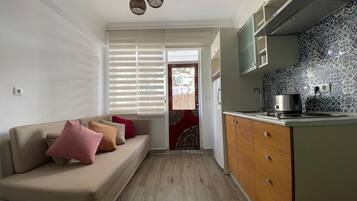 Een mini-koelkast, een vaatwasser, kookgerei, borden en bestek