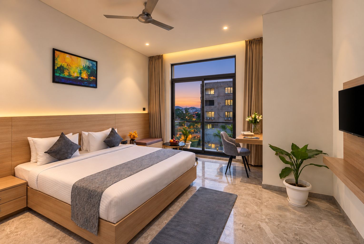 A modern hotel room with a large bed, a desk, a chair, a television, and a balcony with a city view.