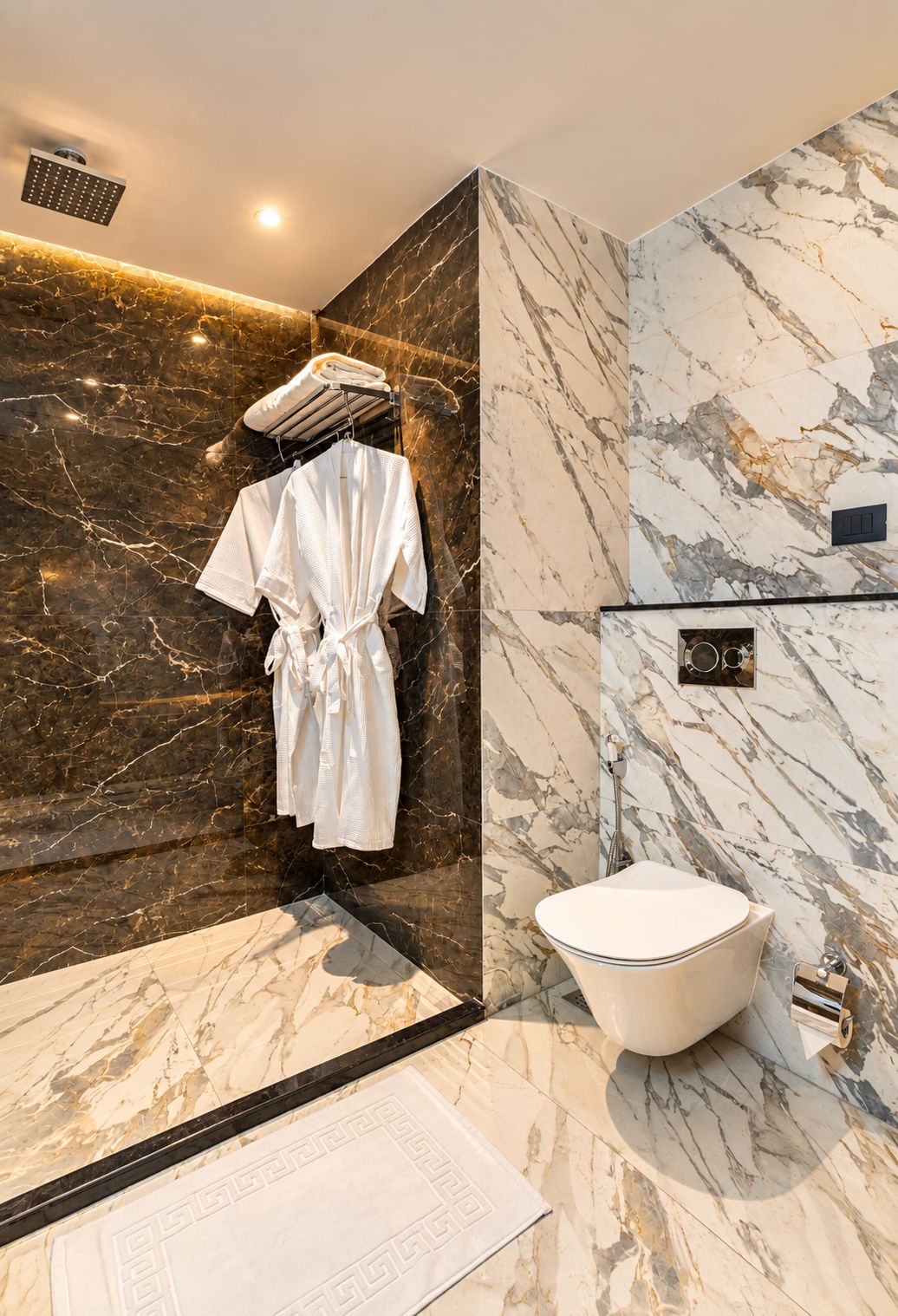 Un bagno moderno con parete in marmo, una vasca da bagno bianca e un accappatoio su un appendiabiti.